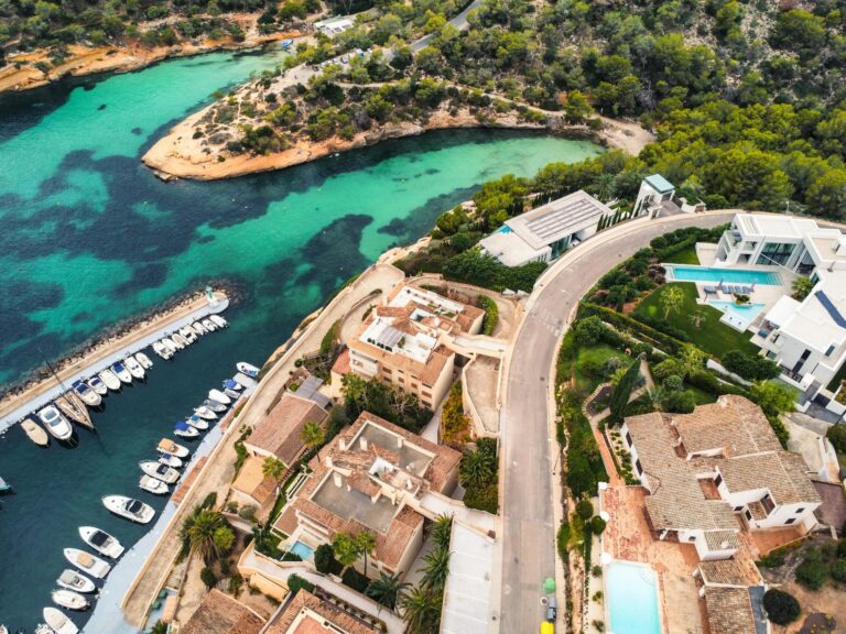 Aerial shot of luxury coastal homes, marina, and turquoise waters.