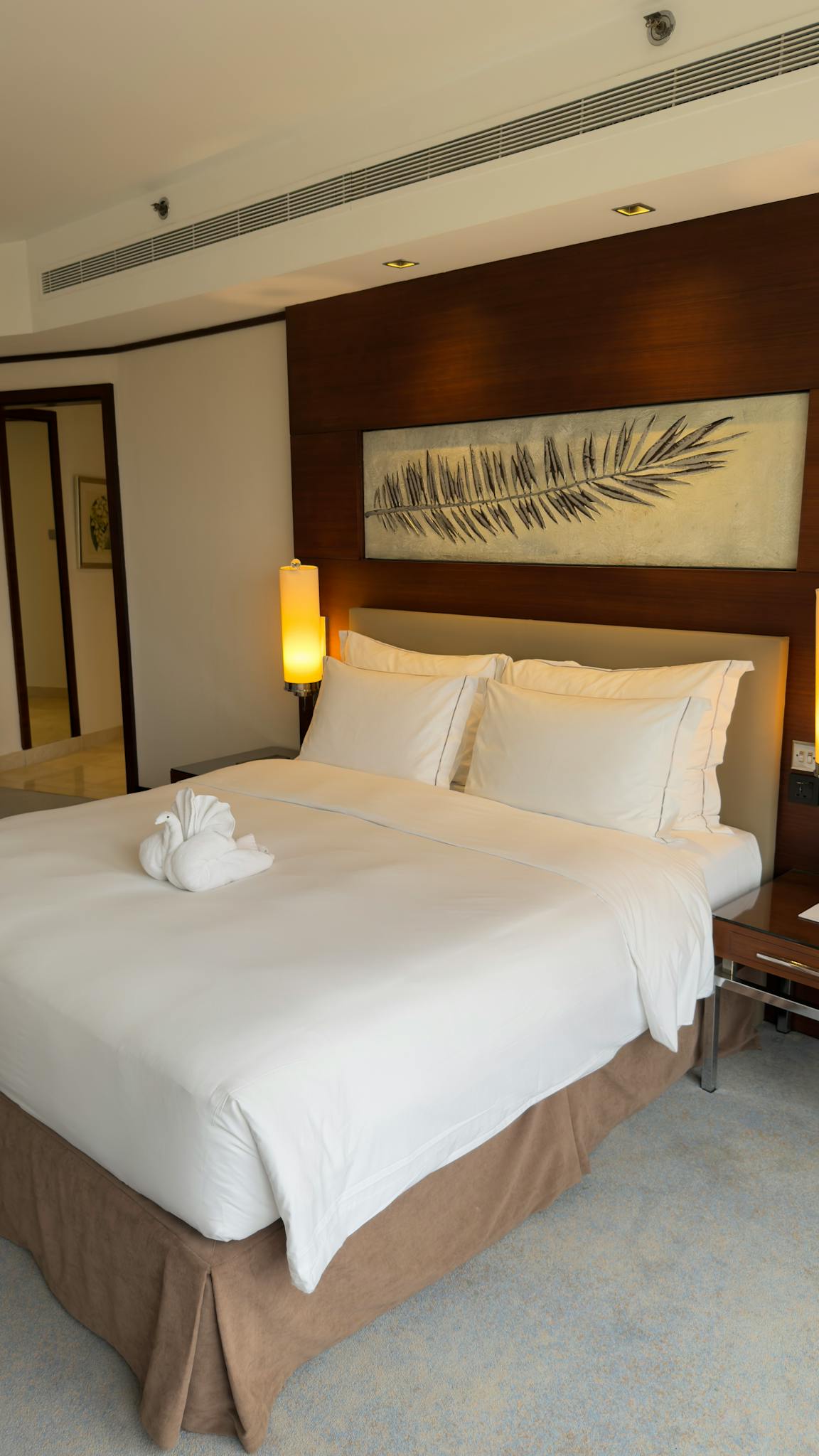 Spacious hotel room featuring a plush bed and modern decor, perfect for relaxation.