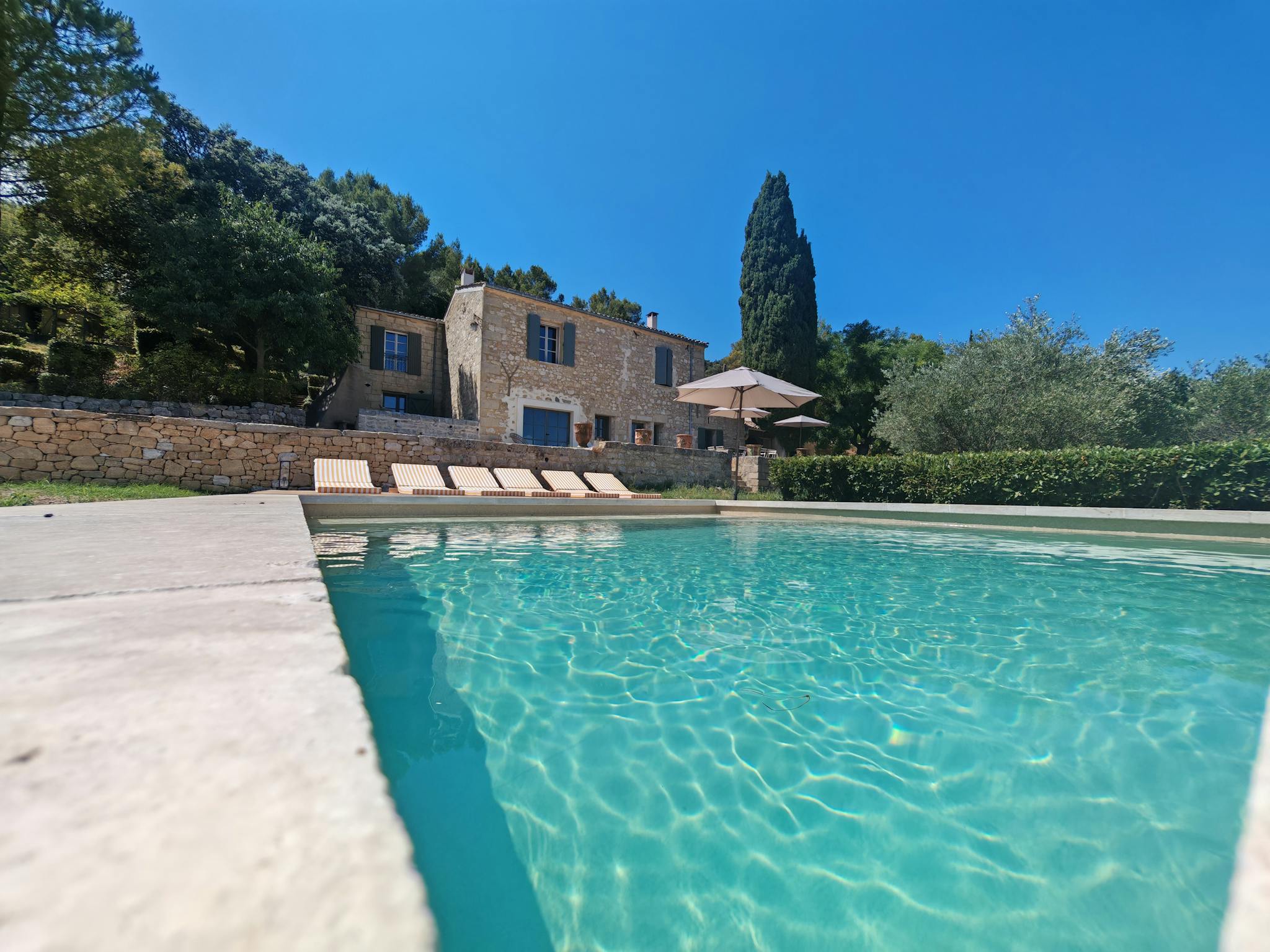 Stunning Mediterranean villa with pristine pool, lush greenery, perfect summer retreat.